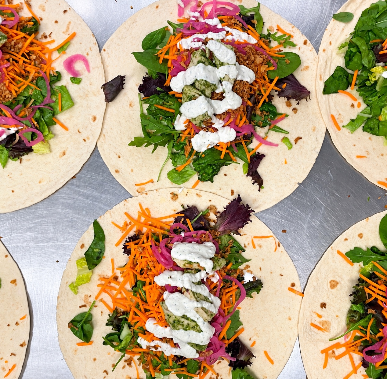 Wraps byggs efter hand ute i restaurangen – sallad, picklad rödlök och egen dressing